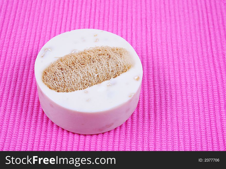 Soap and exfoliator on a pick background - spa products