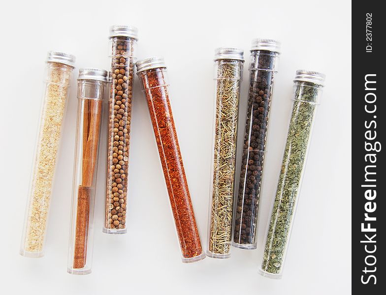 A variety of seven different spice containers against a white background. A variety of seven different spice containers against a white background.