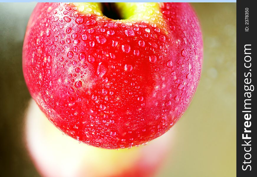 Pink apple with waterdroplets on amirror