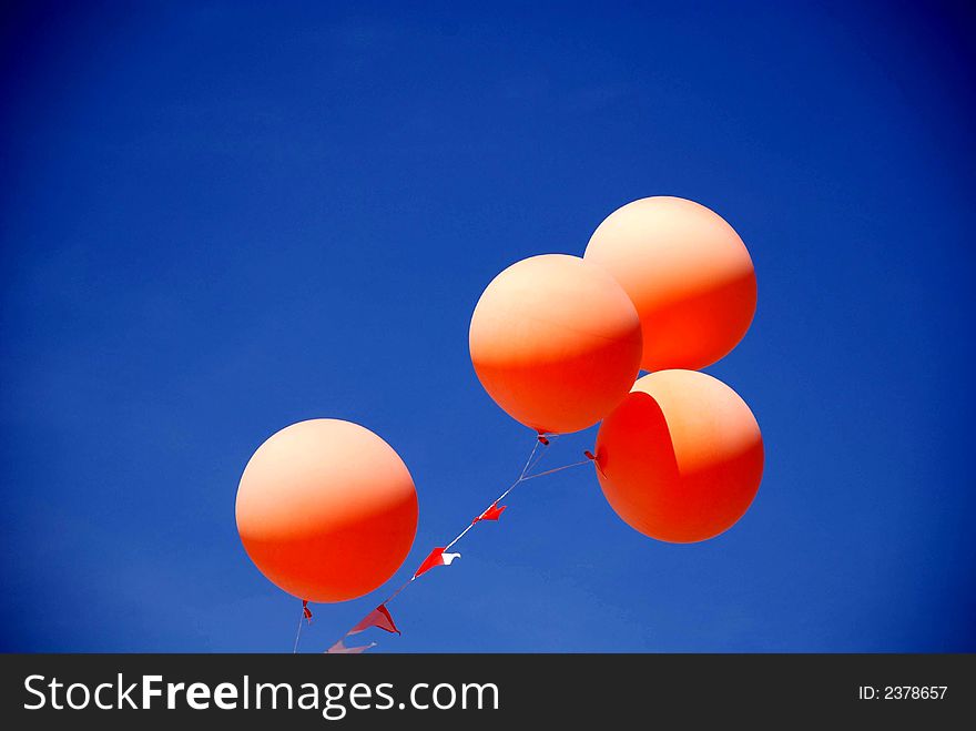 Orange Balloons Floating in the Spring Sun