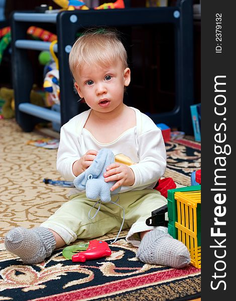 Cute little boy sitting on the floor playing toys. Cute little boy sitting on the floor playing toys