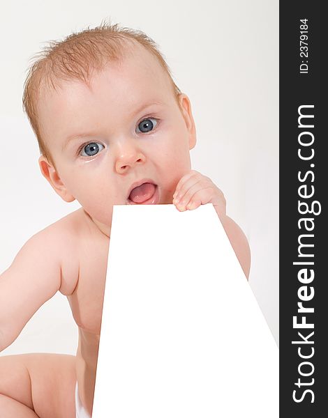 Cute little baby looking into camera, holding a paper sheet. Cute little baby looking into camera, holding a paper sheet