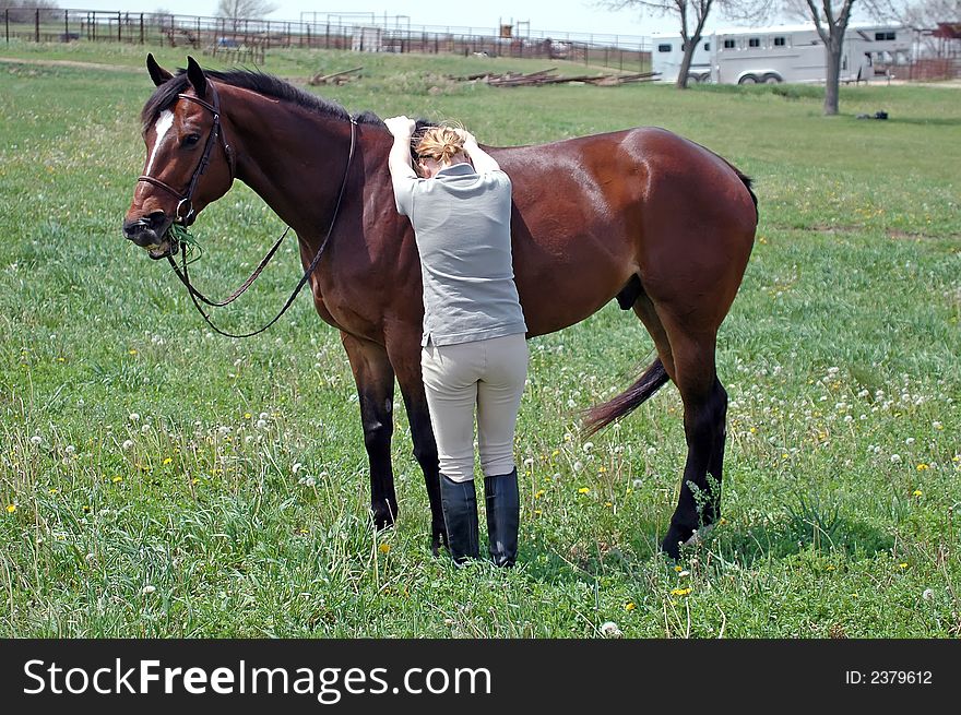 Woman trying to mount horse bareback in field. Woman trying to mount horse bareback in field.