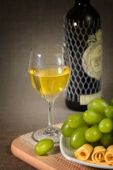 A Glass Of White Wine, Green Grapes And A Bottle O Stock Photo A Glass Of White Wine, Green Grapes And A Bottle O Stock Photo