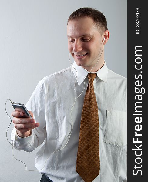 Young smiling businessman listening to music