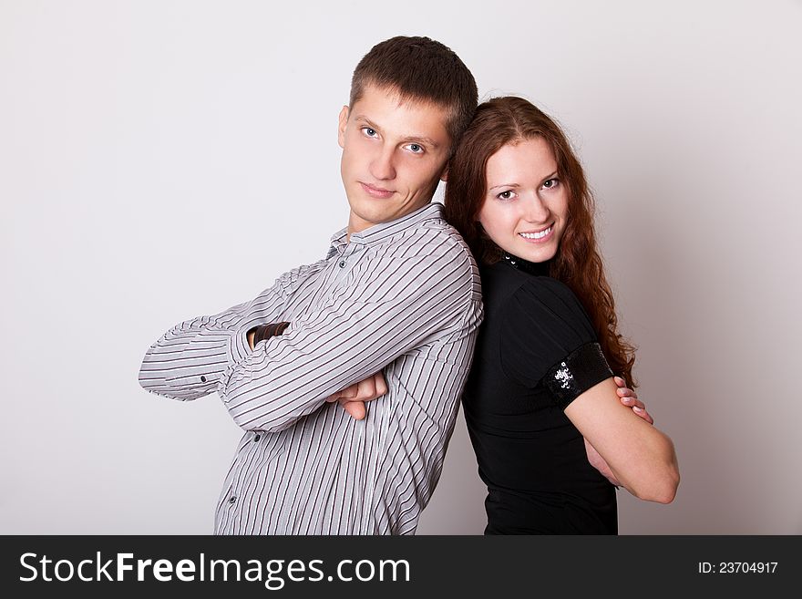 Young couple with folded hands and look camera