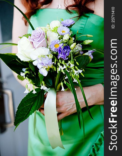 Bridal Bouquet of Flowers being held by a bridesmaid wearing a green dress