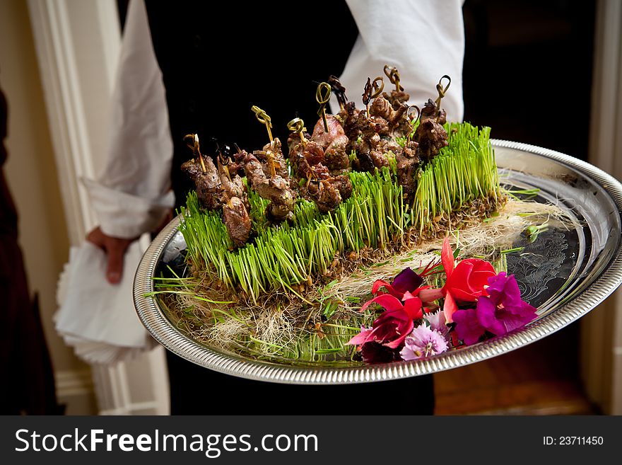 Waiter serving a plate of food during a wedding. Waiter serving a plate of food during a wedding