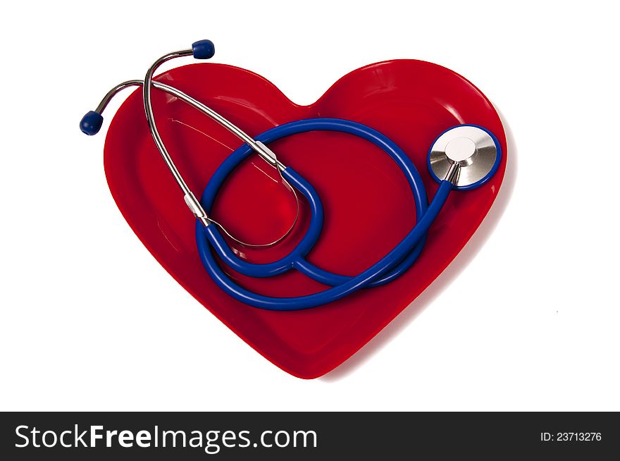 Nice blue stethoscope laying in a red heart-shaped plate.  Isolated on white. Has shadow on the right side. Nice blue stethoscope laying in a red heart-shaped plate.  Isolated on white. Has shadow on the right side.