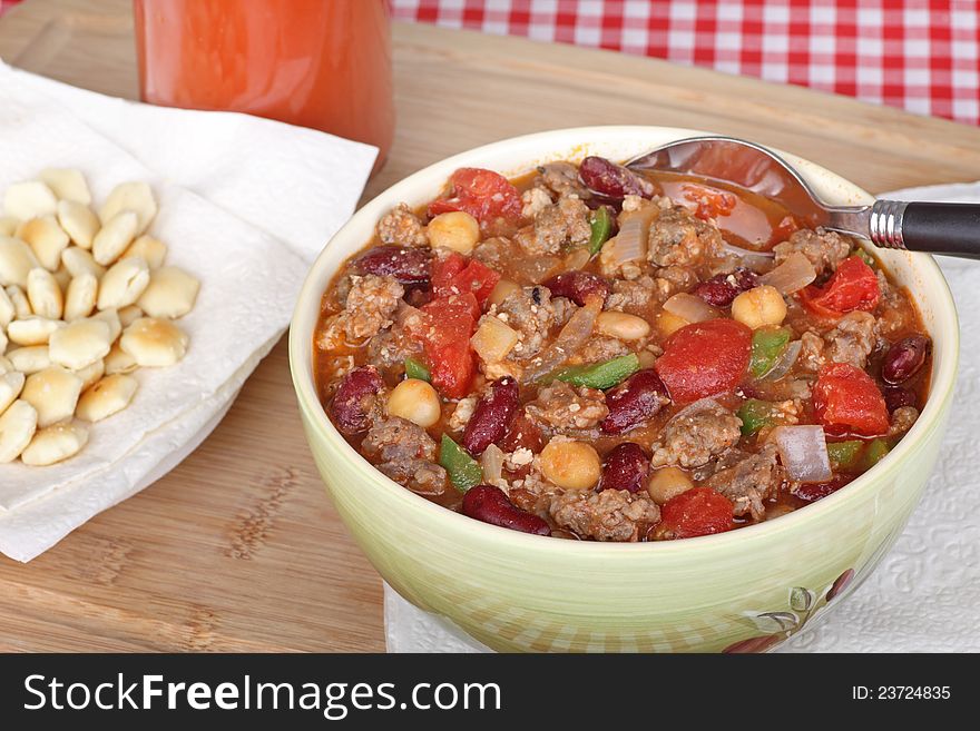 Bowl of chili with meat and crackers on the side. Bowl of chili with meat and crackers on the side