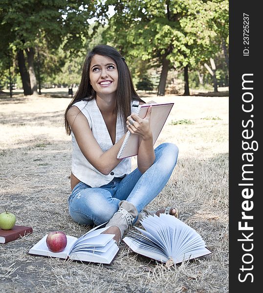 Young woman with notebook photographed in  park. Young woman with notebook photographed in  park