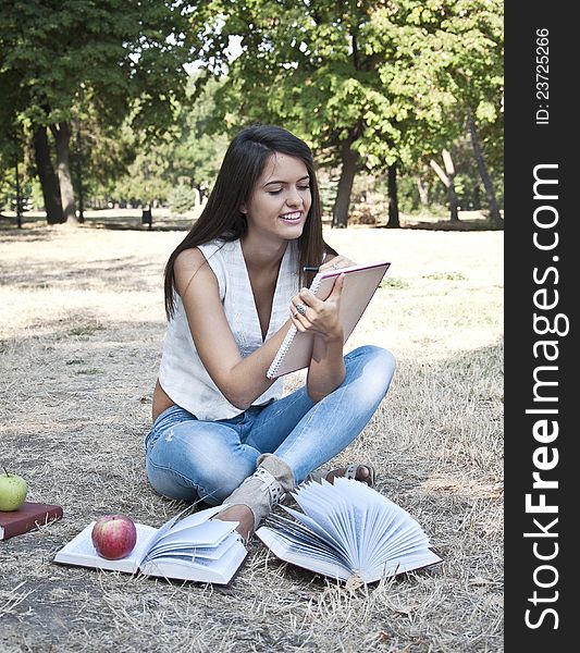 Young woman with notebook photographed in park. Young woman with notebook photographed in park