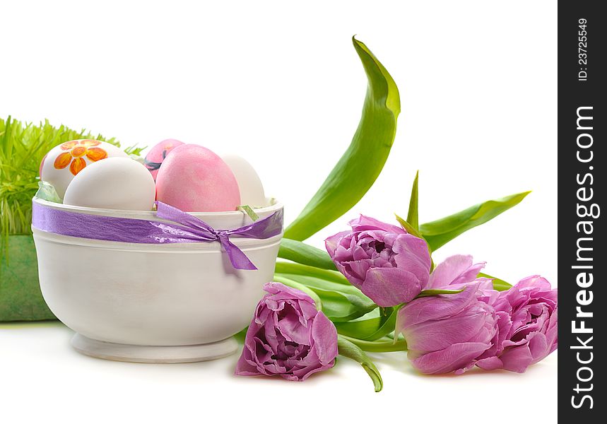 Easter eggs  with tulips and green grass on white background