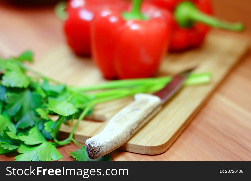 Healthy red peppers, green parsley and knife for cutting and preparing a dinner. Healthy red peppers, green parsley and knife for cutting and preparing a dinner.