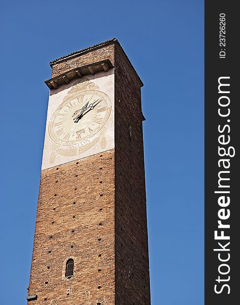 Ancient italian medieval civil tower with clock in the city of Pavia. Ancient italian medieval civil tower with clock in the city of Pavia