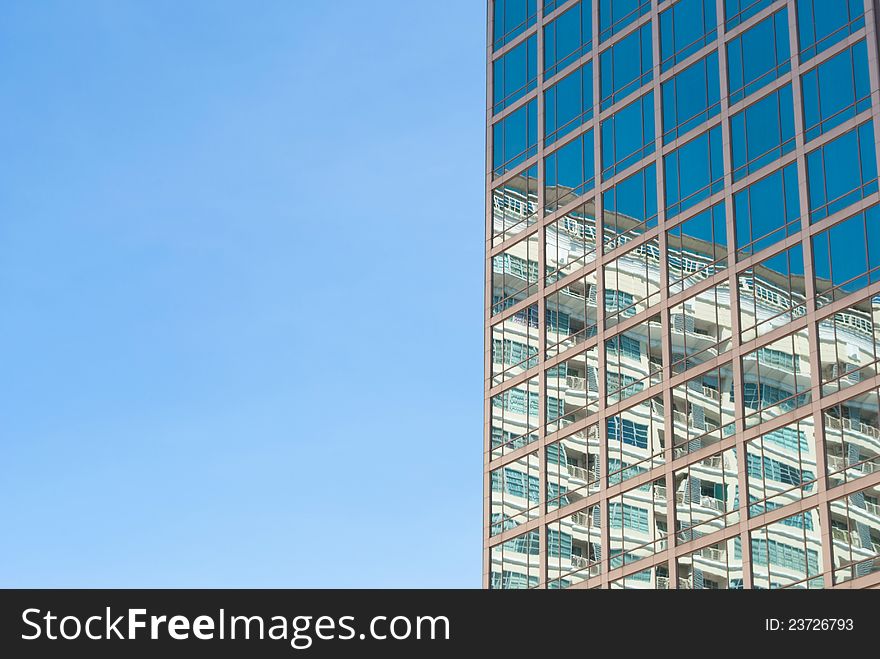 City reflection on blue window in sunny day