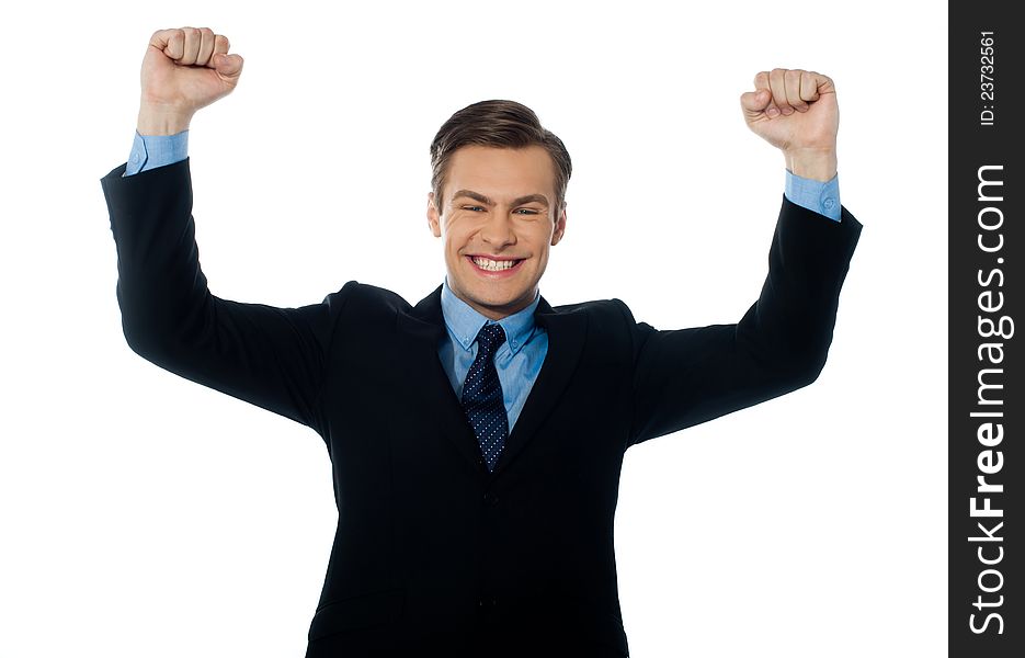 Portrait of confident young businessman celebrating success with arms up