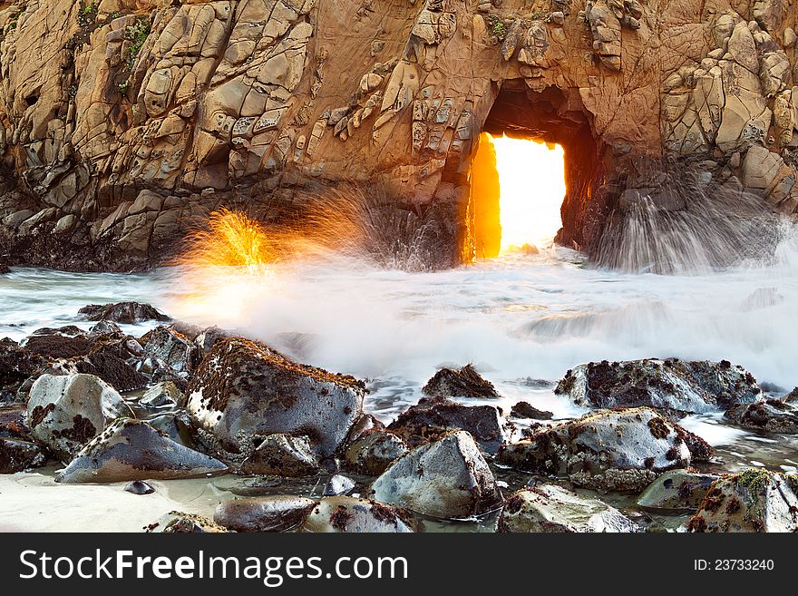 Sunsetting light coming through opening at famous Pfeiffer Beach, California. Sunsetting light coming through opening at famous Pfeiffer Beach, California.