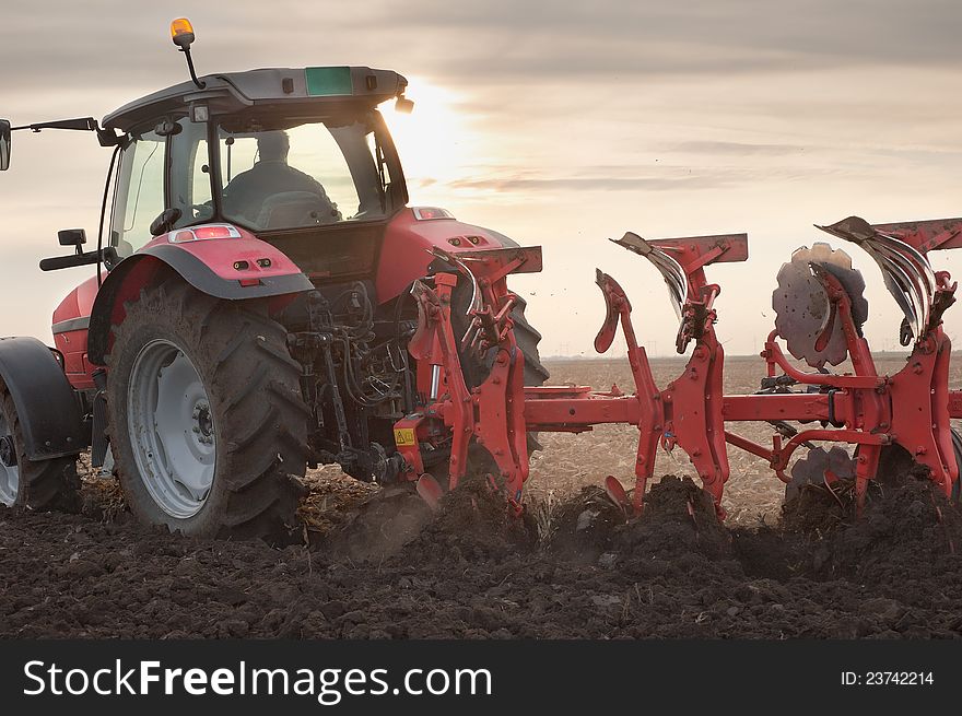 Red Tractor Plowing in Autumn. Red Tractor Plowing in Autumn