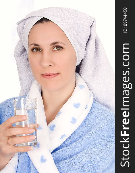 Girl in a bathrobe drinking a glass of water. Girl in a bathrobe drinking a glass of water