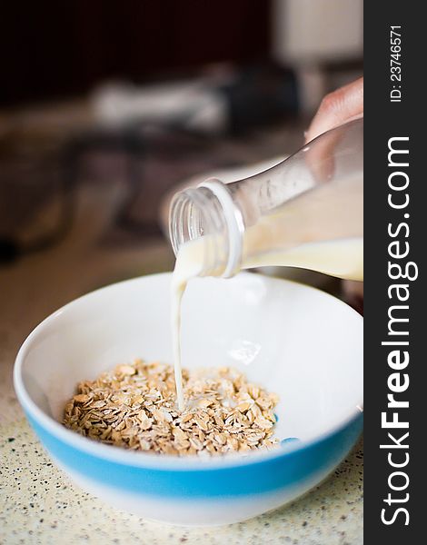 Milk flowing on a bowl of cornflakes