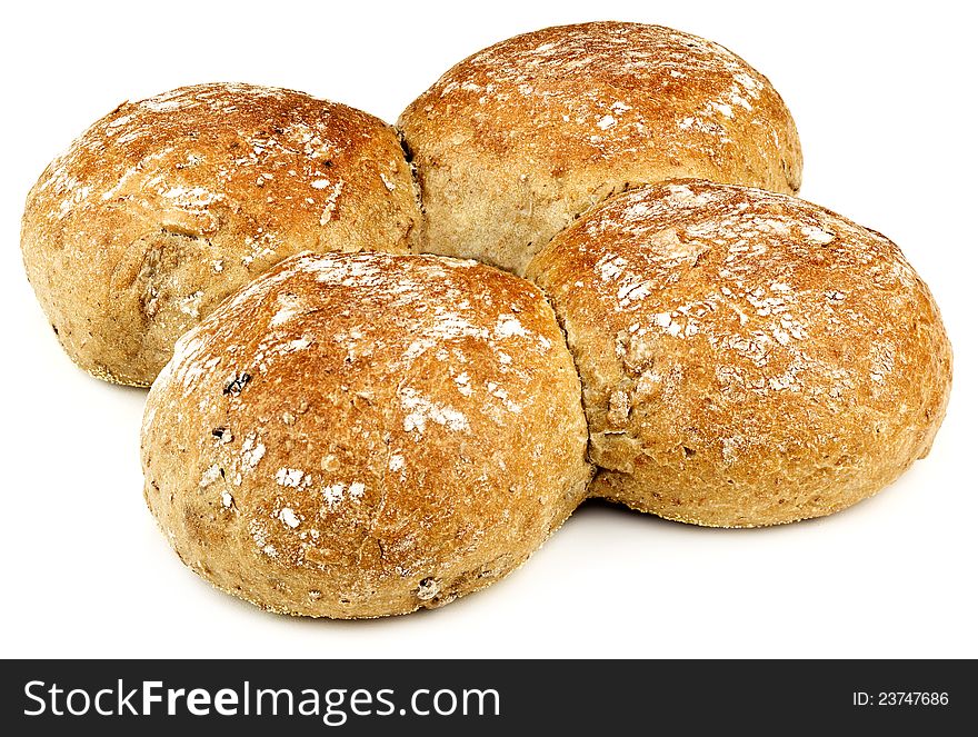 Four buns with a bit of flour on them placed on a white table