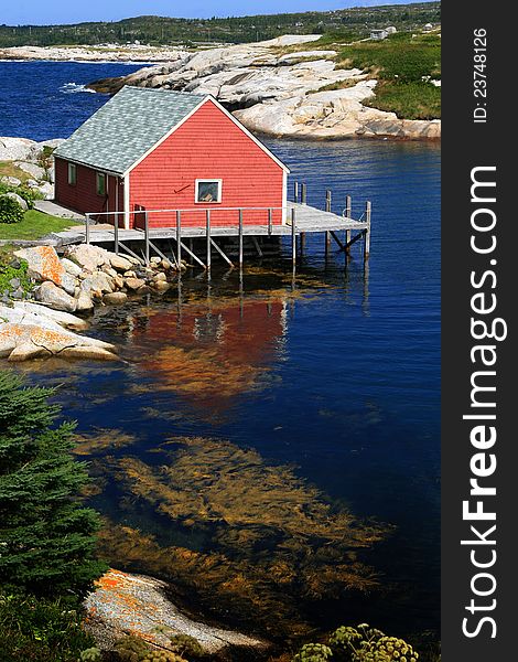 A red house on the blue cove,peggy'cove,Navoscotia,Canada. A red house on the blue cove,peggy'cove,Navoscotia,Canada