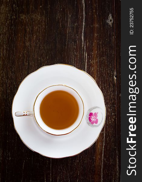 White cup of tea on wooden table