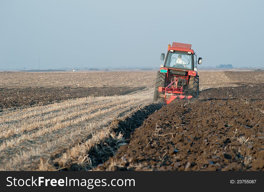 Red Tractor Plowing in autumn