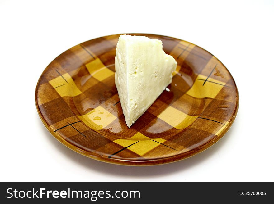 A delicious cheese on a plate closeup on white background. A delicious cheese on a plate closeup on white background