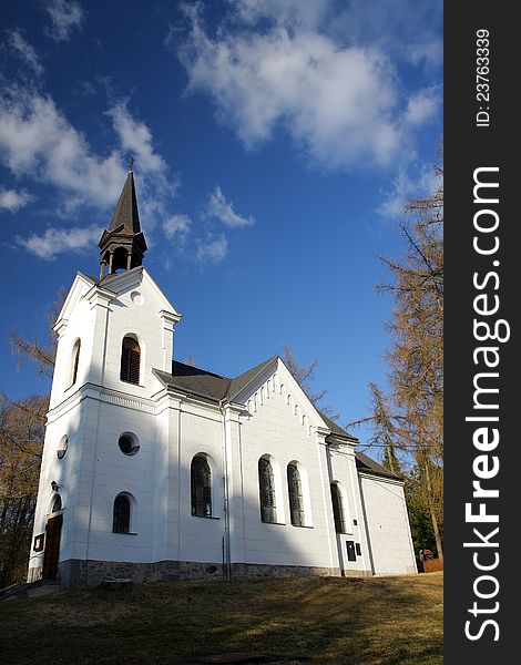 Small white catholic church with blue sky and white clouds. Small white catholic church with blue sky and white clouds