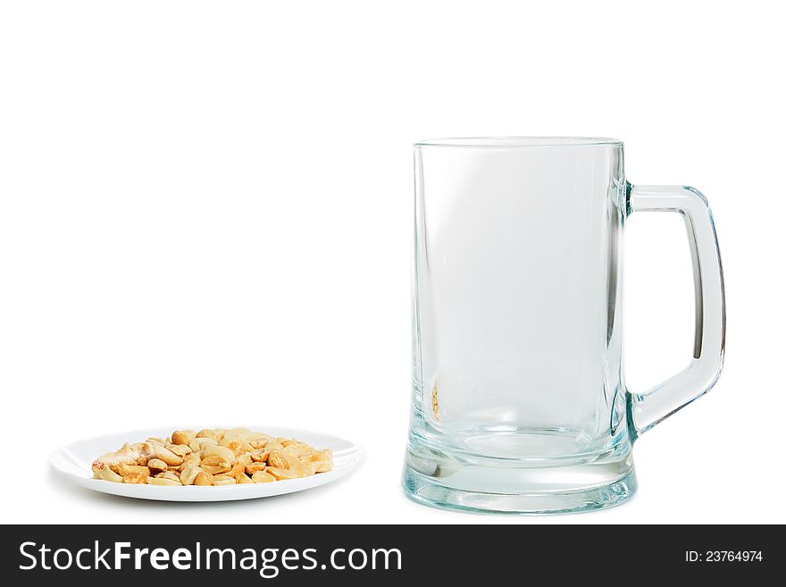 Empty cup of beer and saucer with peanuts