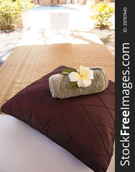 A Bed Near Swimming Pool With Pillow And Towel