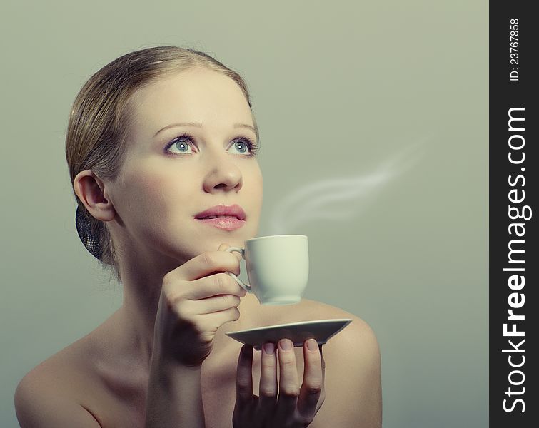 Beauty young woman enjoying a cup of coffee