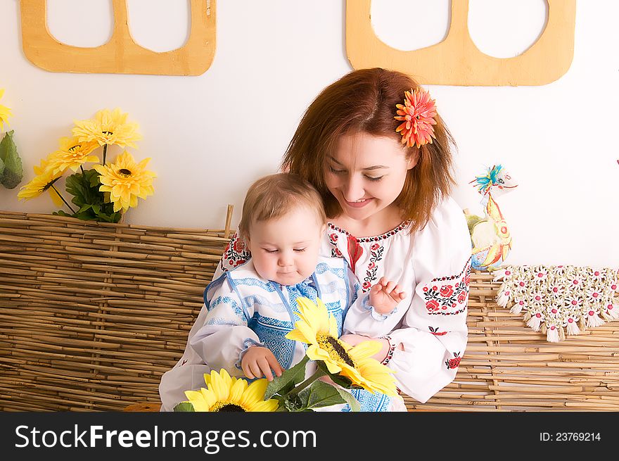 Mother playing with her little daughter. In the Ukrainian national costumes. Mother playing with her little daughter. In the Ukrainian national costumes