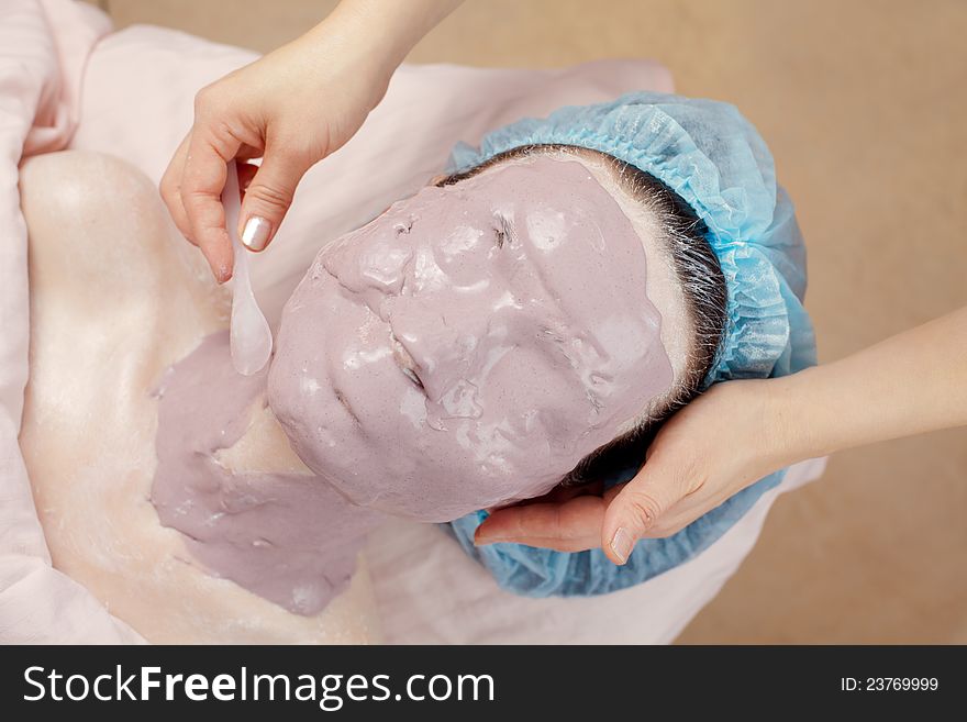Facial seaweed mask applying in beauty salon