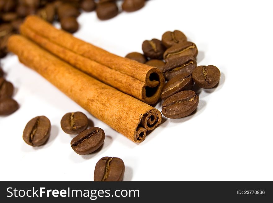 Cinnamon sticks and coffee beans on white background