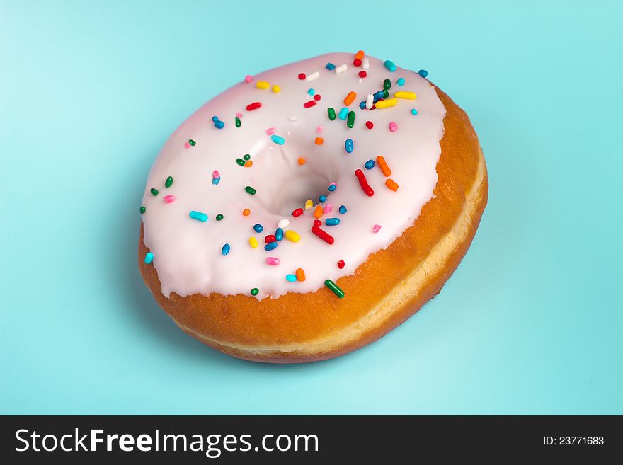 Iced, glazed donut with rainbow sprinkles