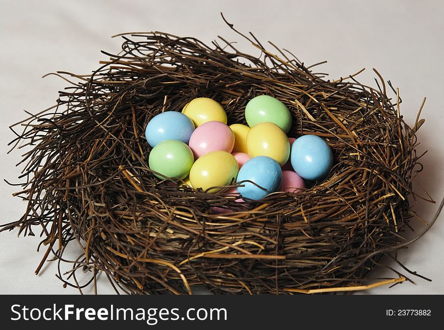 Birds nest full of colorful chocolate easter eggs. Birds nest full of colorful chocolate easter eggs