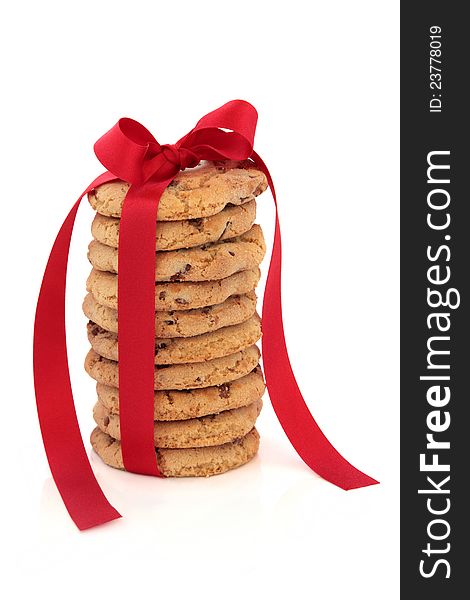 Chocolate chip cookie stack tied with a red satin ribbon over white background. Chocolate chip cookie stack tied with a red satin ribbon over white background.