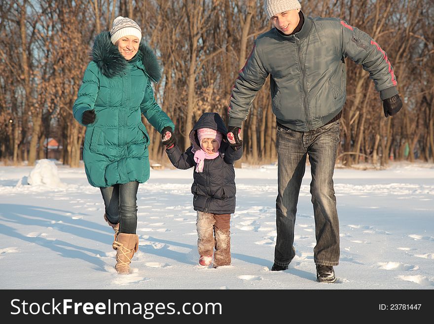 Happy family lying on the snow in the winter