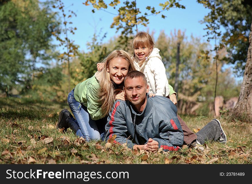 Young happy family in autumn park. Young happy family in autumn park.