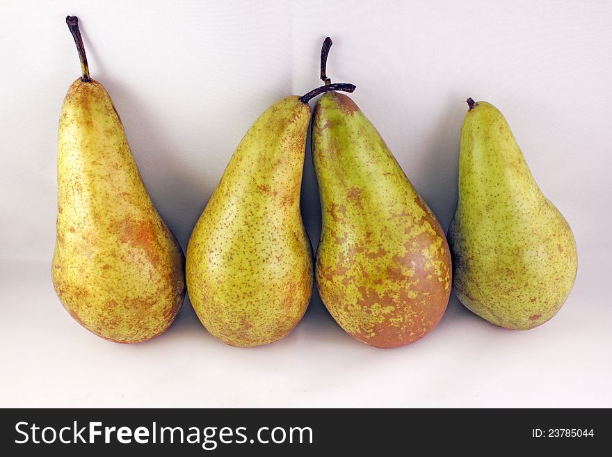 Four juicy ripe golden pears on a gray background. Healthy food. Four juicy ripe golden pears on a gray background. Healthy food.