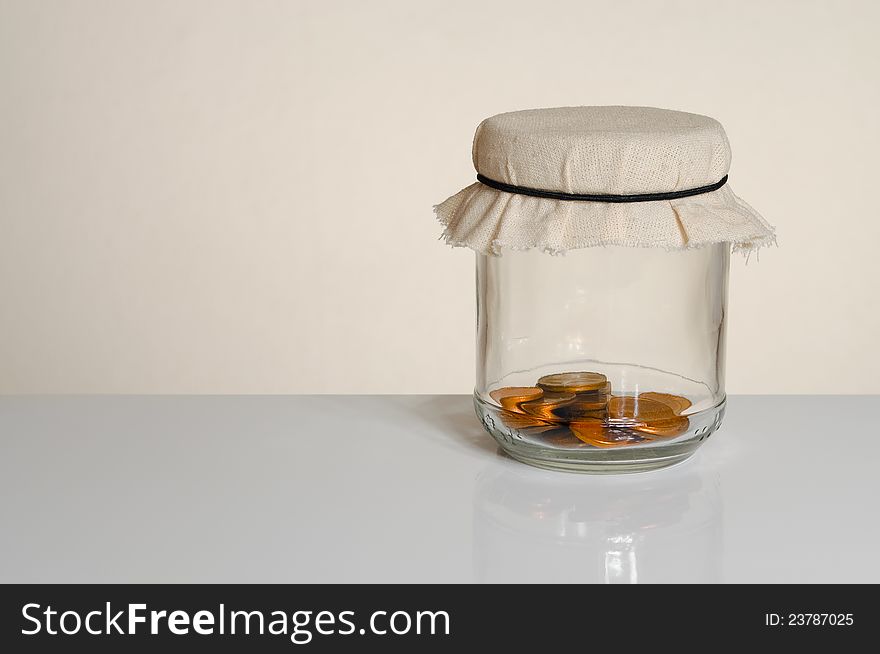 Savings - coins in a jar with copy space