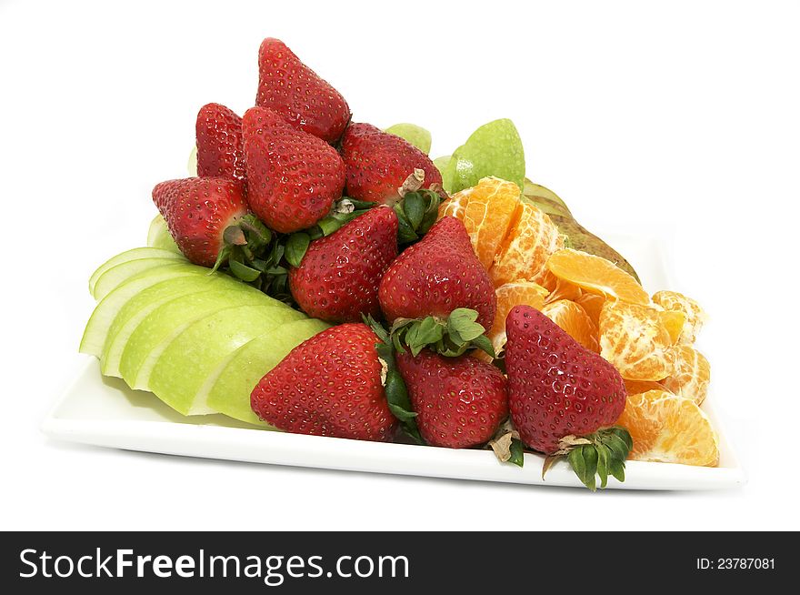 A large plate of sliced fruit on white background. A large plate of sliced fruit on white background