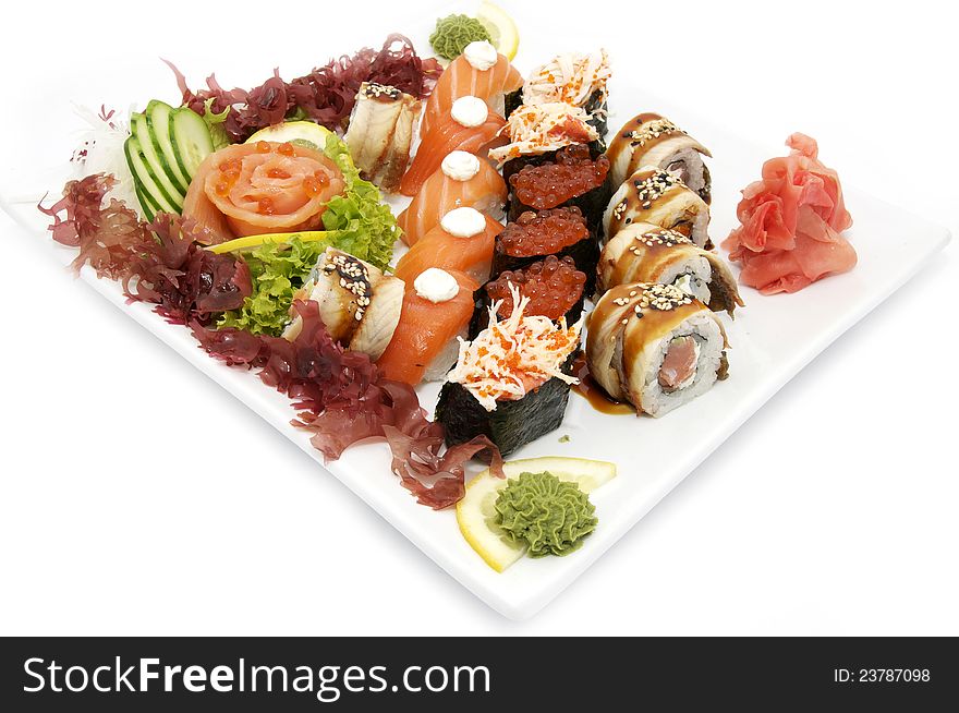 Plate of sushi beautifully decorated with salad and fruit on a white background