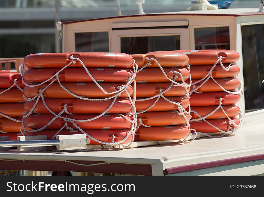 Stacked lifebelts over a ship deck on a sunny day