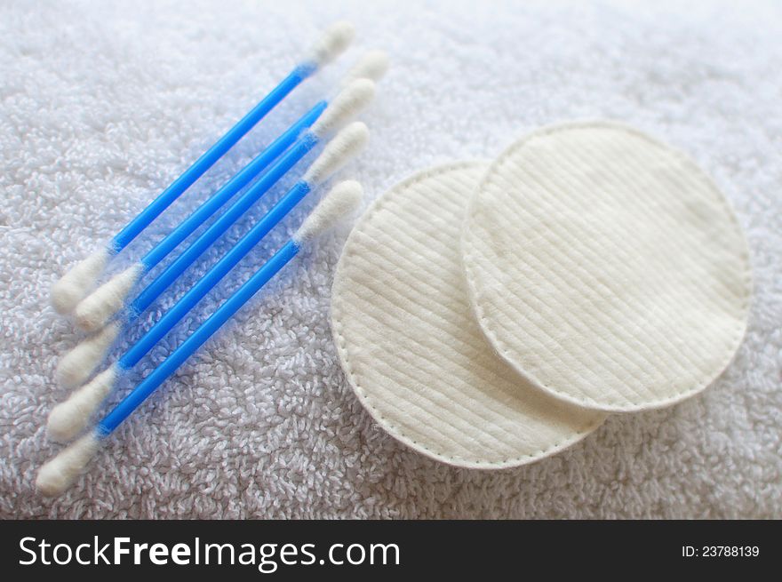 Objects for body-care and personal hygiene: cotton swabs and pads on white towel