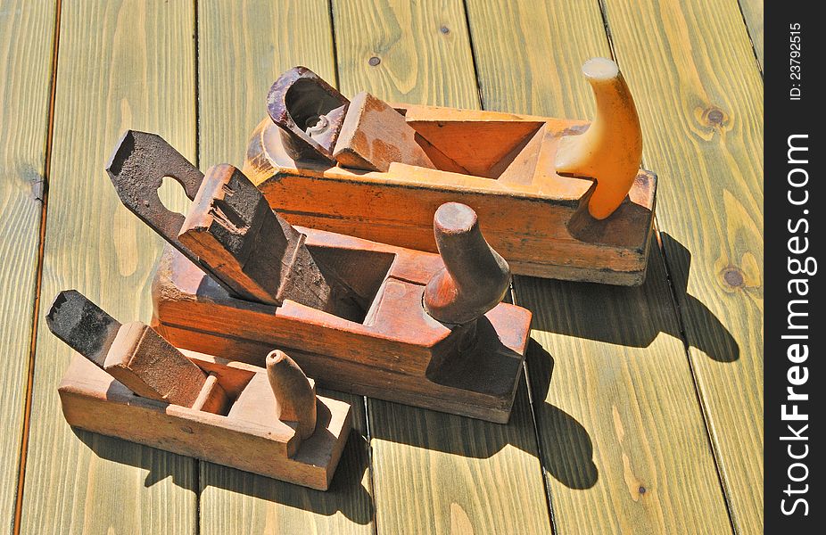 Three old planer made â€‹â€‹of solid wood lying on a wooden table. Three old planer made â€‹â€‹of solid wood lying on a wooden table