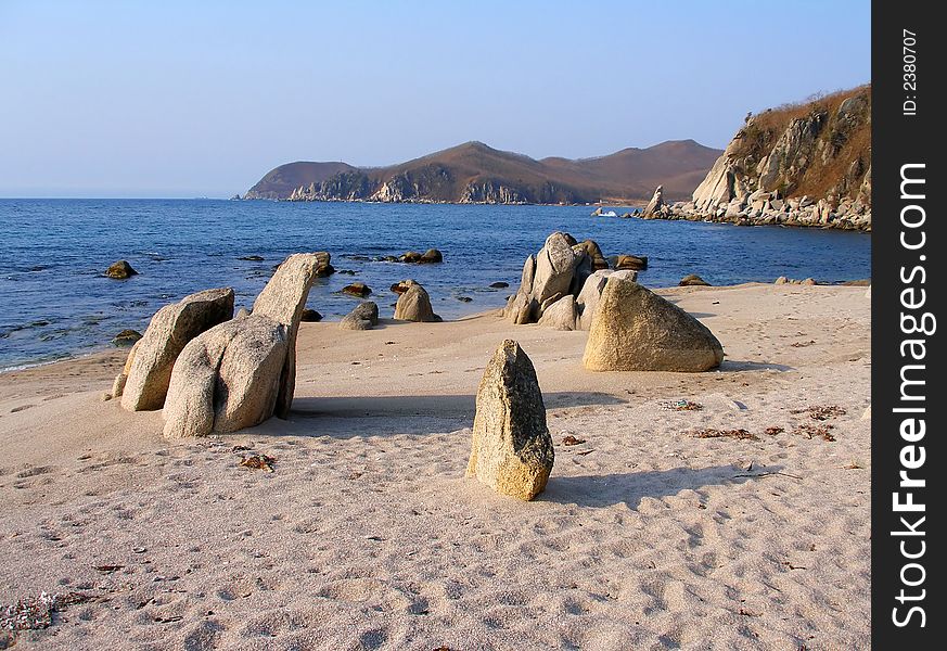 Coast of Sea of Japan, sand beach, stones, rocks, summer morning, landscape. Coast of Sea of Japan, sand beach, stones, rocks, summer morning, landscape